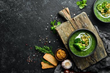 Siyah kasede yeşil kremalı brokoli çorbası ve kabak çekirdeği. Üst Manzara. Metnin için boş yer. Kırsal biçim.