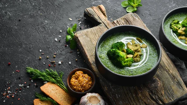 西兰花汤的绿色奶油和在黑碗中的南瓜籽 顶部视图 为你的文字腾出空间 乡村风格 — 图库照片