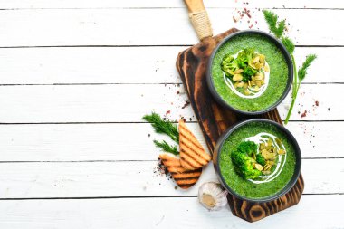Siyah kasede yeşil kremalı brokoli çorbası ve kabak çekirdeği. Üst Manzara. Metnin için boş yer. Kırsal biçim.