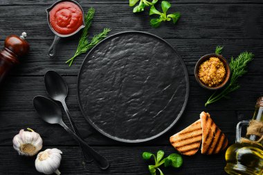 Baharatlı ve tabaklı siyah mutfak arka planı. Üst Manzara. Metnin için boş yer. Kırsal biçim.