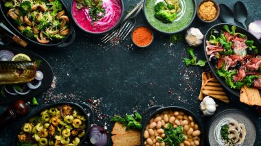 Restoran menüsü. Siyah taş arka planda yemek ve tabaklar. Üst görünüm.