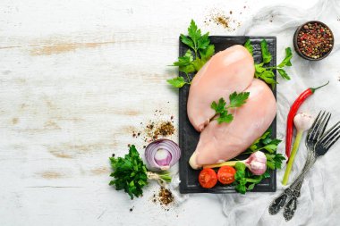 Çiğ tavuk göğsü, maydanozlu ve masada baharatlı. Üst Manzara. Metnin için boş yer. Kırsal biçim.