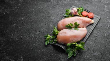 Çiğ tavuk göğsü, maydanozlu ve masada baharatlı. Üst Manzara. Metnin için boş yer. Kırsal biçim.