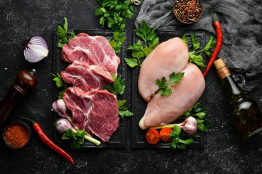 Et arka planı. Dana biftek ve tavuk göğsü. Üst Manzara. Siyah taştan bir arka planda.
