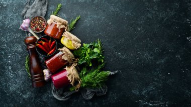 Cam kavanozlarda soslar. Hardal, domates sosu ve yaban turpu sosu. Üst görünüm.