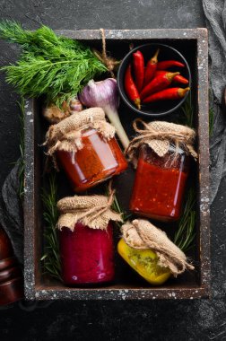 Cam kavanozlarda soslar. Hardal, domates sosu ve yaban turpu sosu. Üst görünüm.