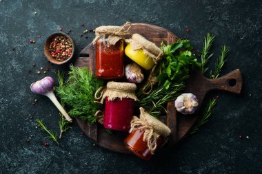 Cam kavanozlarda soslar. Hardal, domates sosu ve yaban turpu sosu. Üst görünüm.