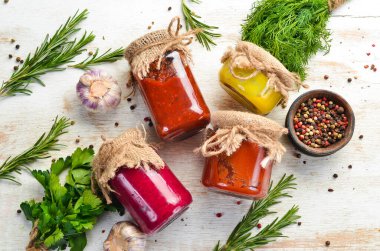 Cam kavanozlarda soslar. Hardal, domates sosu ve yaban turpu sosu. Üst görünüm.