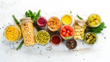 Cam kavanozlardaki yiyecek stoklarının arka planı. Sebze ve mantar turşusu. Üst görünüm.