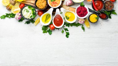 Beyaz ahşap arka planda soslar ve baharatlar. Üst görünüm.