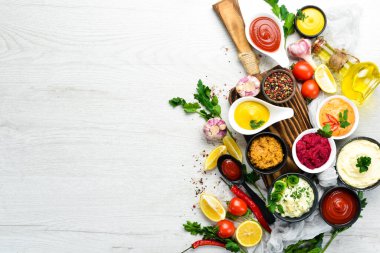 Beyaz ahşap arka planda soslar ve baharatlar. Üst görünüm.