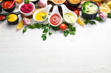 Beyaz ahşap arka planda soslar ve baharatlar. Üst görünüm.