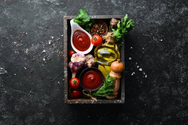 Domatesli ketçap sosu. Acı kırmızı sos. Siyah taştan bir arka planda.