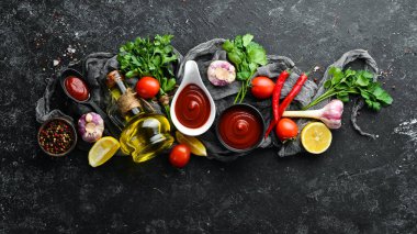 Domatesli ketçap sosu. Acı kırmızı sos. Siyah taştan bir arka planda.