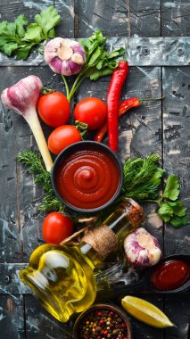 Domatesli ketçap sosu. Acı kırmızı sos. Siyah taştan bir arka planda.