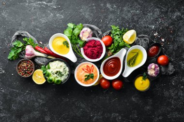 Taş zeminde soslar ve baharatlar. Sos: Mayonez, ketçap, tartar, barbekü ve biber sosu..