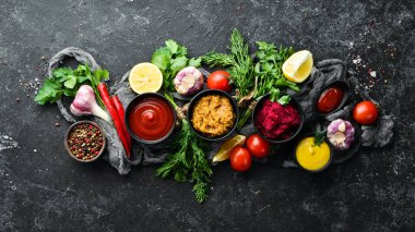 Taş zeminde soslar ve baharatlar. Sos: Mayonez, ketçap, tartar, barbekü ve biber sosu..