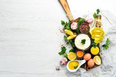 Ev yapımı mayonez sosu ve beyaz ahşap arka planda malzemeler. Üst Manzara. Metnin için boş yer.