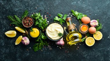 Mayonez sosu ve siyah taş zemin üzerindeki malzemeler. Üst görünüm.