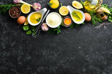 Mayonez sosu ve siyah taş zemin üzerindeki malzemeler. Üst görünüm.
