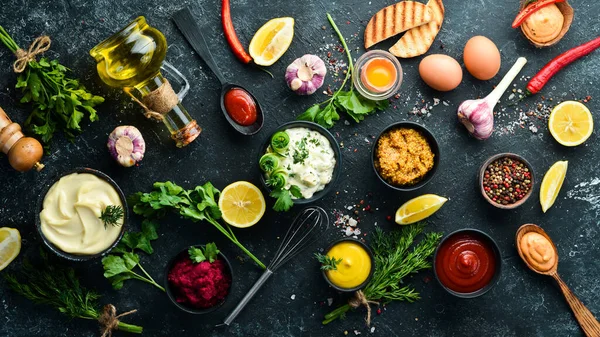 Taş zeminde soslar ve baharatlar. Sos: Mayonez, ketçap, tartar, barbekü ve biber sosu..