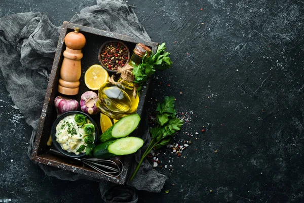 Siyah arka planda salatalık, limon ve sarımsaklı ev yapımı Yunan sosu. Üst Manzara. Metnin için boş yer.