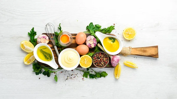 Ev yapımı mayonez sosu ve beyaz ahşap arka planda malzemeler. Üst Manzara. Metnin için boş yer.