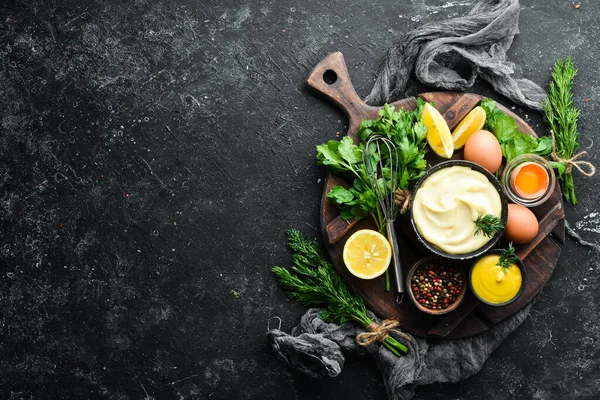 Mayonez sosu ve siyah taş zemin üzerindeki malzemeler. Üst görünüm.