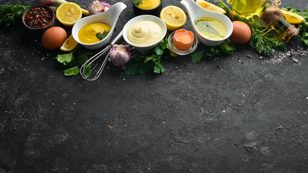 Mayonez sosu ve siyah taş zemin üzerindeki malzemeler. Üst görünüm.