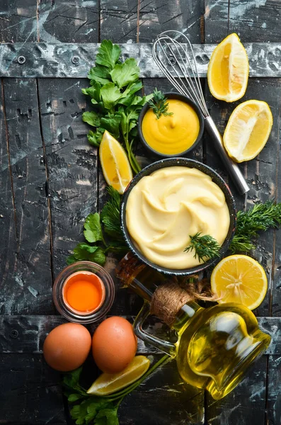 Mayonez sosu ve siyah taş zemin üzerindeki malzemeler. Üst görünüm.
