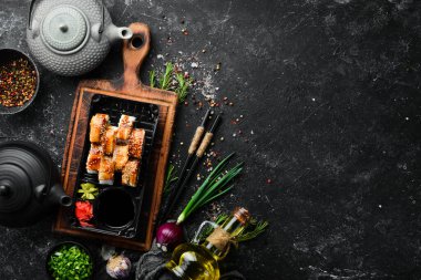 Lezzetli Japon suşisi, yılan balığı ve Philadelphia peynirli. Plastik kutularda yiyecek teslimatı. Üst görünüm.