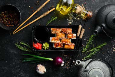 Lezzetli Japon suşisi, yılan balığı ve Philadelphia peynirli. Plastik kutularda yiyecek teslimatı. Üst görünüm.