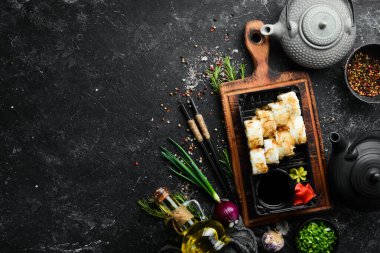 Peynirli suşi ve ton balığı cipsi, wasabi ve soya sosu plastik bir kutuda. Üst görünüm.