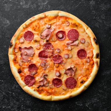 Masada domuz pastırması ve salamlı ev yapımı pizza. Kırsal tarzda. Üst görünüm.