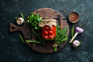 Cam kavanozda vişneli domates turşusu. Yiyecek stokları. Üst görünüm.