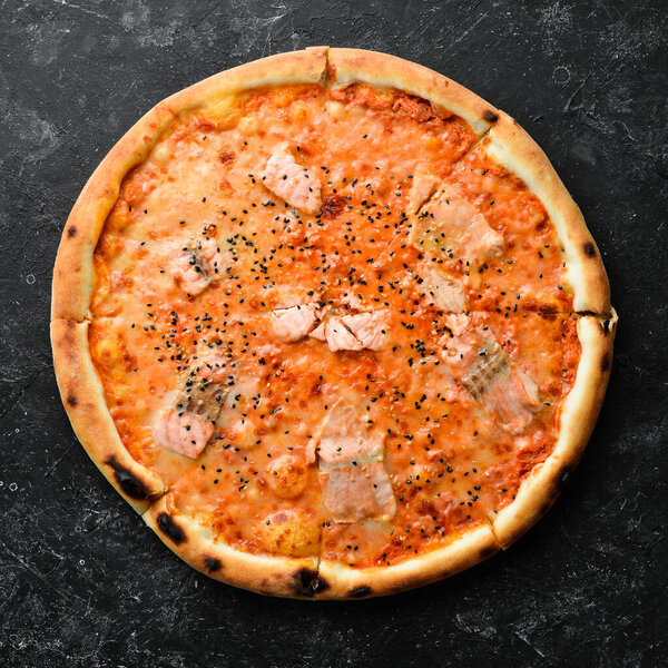 Pizza with salmon and tomato sauce. Italian cuisine. Food delivery. Top view.