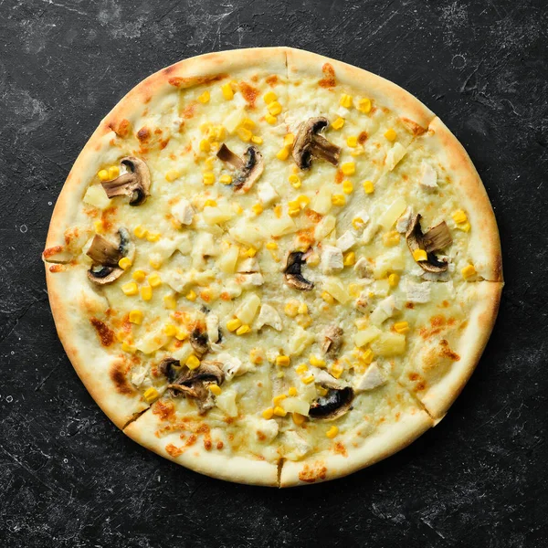 Hawaiian pizza with chicken, pineapple and mushrooms on the table. Rustic style. Top view.