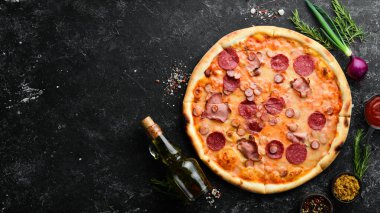 Masada domuz pastırması ve salamlı ev yapımı pizza. Kırsal tarzda. Üst görünüm.
