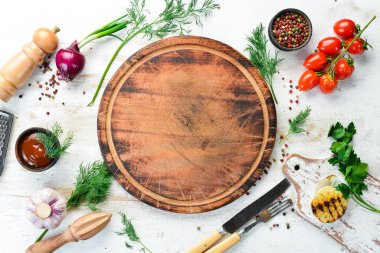 Beyaz mutfak geçmişi. Mutfak tahtası, sebzeler ve baharatlar beyaz ahşap arka planda. Üst görünüm.