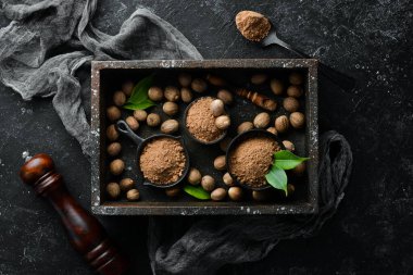 Siyah taş arka planda kâse içinde hindistan cevizi. Kokulu Hint baharatları. Metnin için boş yer. Üst görünüm.