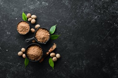 Siyah taş arka planda kâse içinde hindistan cevizi. Kokulu Hint baharatları. Metnin için boş yer. Üst görünüm.