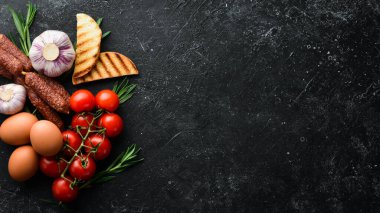 Yemek arkaplanı: yemek malzemeleri. Eski bir arka planda domates, mantar, biberiye, yumurta ve baharat. Üst görünüm.