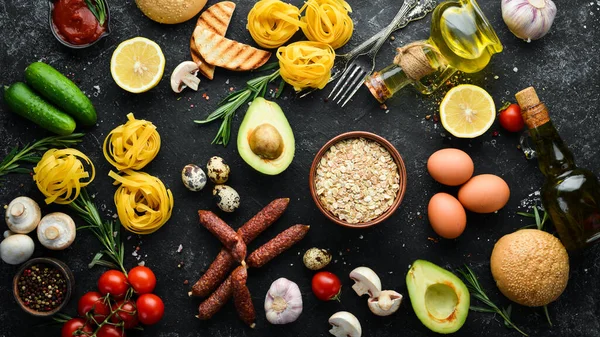 健康食品のセット トマト パスタ スパイス 野菜やソーセージ 最上階だ 黒石の背景 — ストック写真