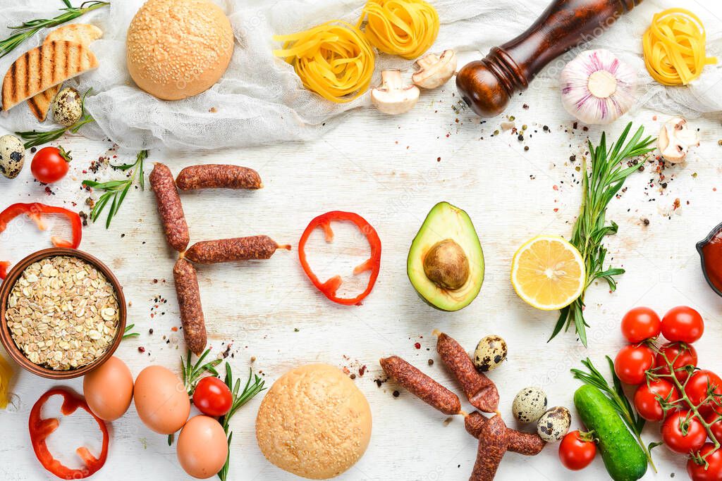 Ingredients of healthy nutrition. Cooking background: Eggs, oatmeal, sausages and fresh vegetables on a white wooden background.