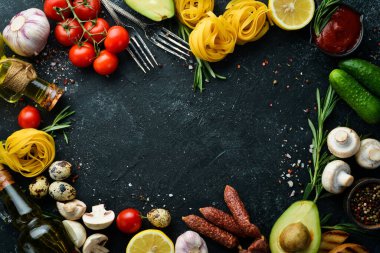 Tagliatelle makarna ve malzeme pişirme geçmişi. İtalyan mutfağının siyah taş arka planı. Üst görünüm.
