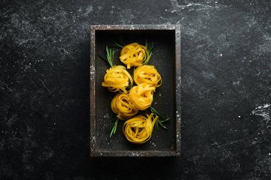 Çiğ tagliatelle makarna ve malzemeler. Gıda arkaplanı.