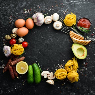 Kuru makarna ve yemek malzemeleri. Siyah yemek geçmişi. Metnin için boş yer.