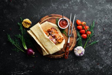 Pita ekmeğinde soğanlı tavuk kebabı. Et şişleri. Üst görünüm.