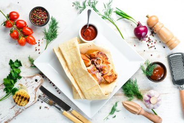 Pita ekmeğinde soğanlı tavuk kebabı. Et şişleri. Üst görünüm.