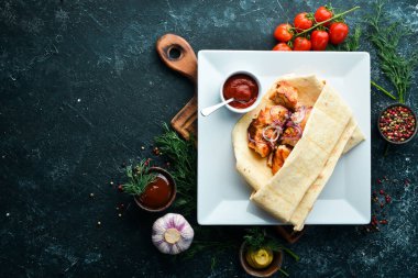 Pita ekmeğinde soğanlı tavuk kebabı. Et şişleri. Üst görünüm.